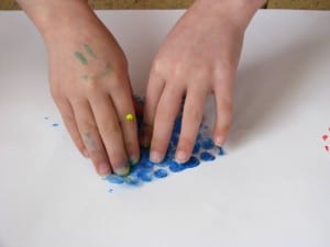 Pressing gently to transfer the paint onto paper