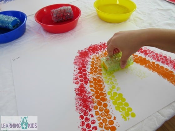 Painting a rainbow with bubble wrap covered blocks by learning 4 kids