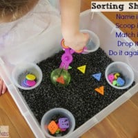 Sorting shapes activity using a sensory bin and scooper scissors by learning 4 kids