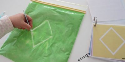 Drawing shapes on a sensory Squishy bag with free printable shapes flip book