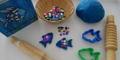 invitation to play with the rainbow fish story book and play dough with sequins